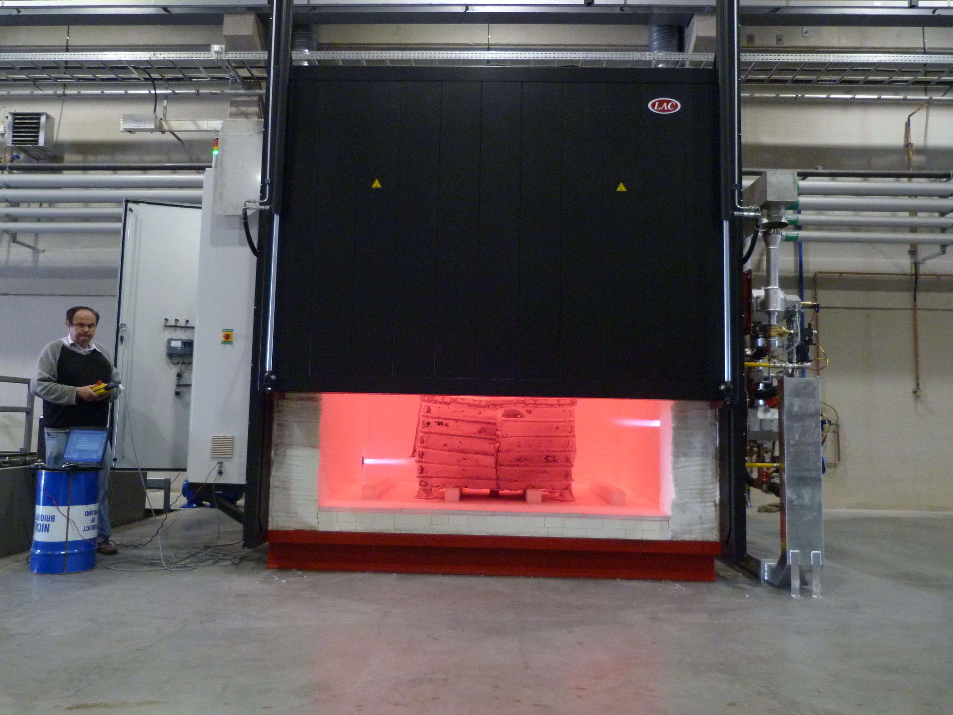 Industrial high-temperature furnace with a glowing chamber and load during heat treatment